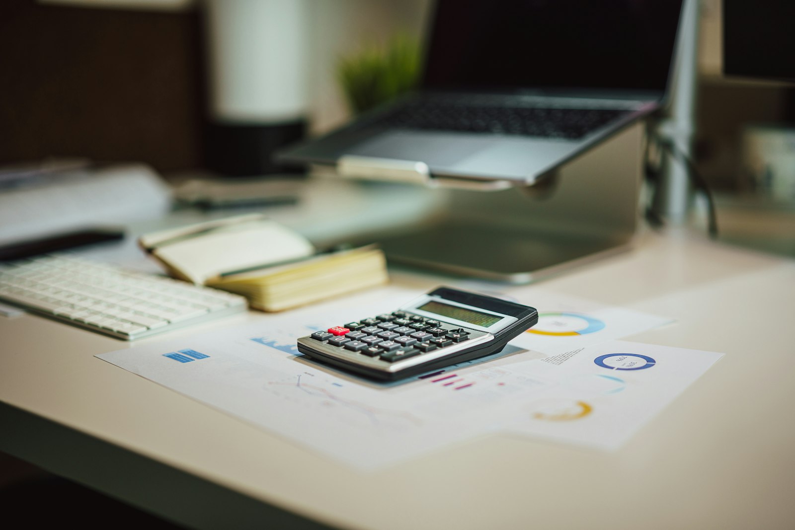 Calculator next to a laptop on a desk
