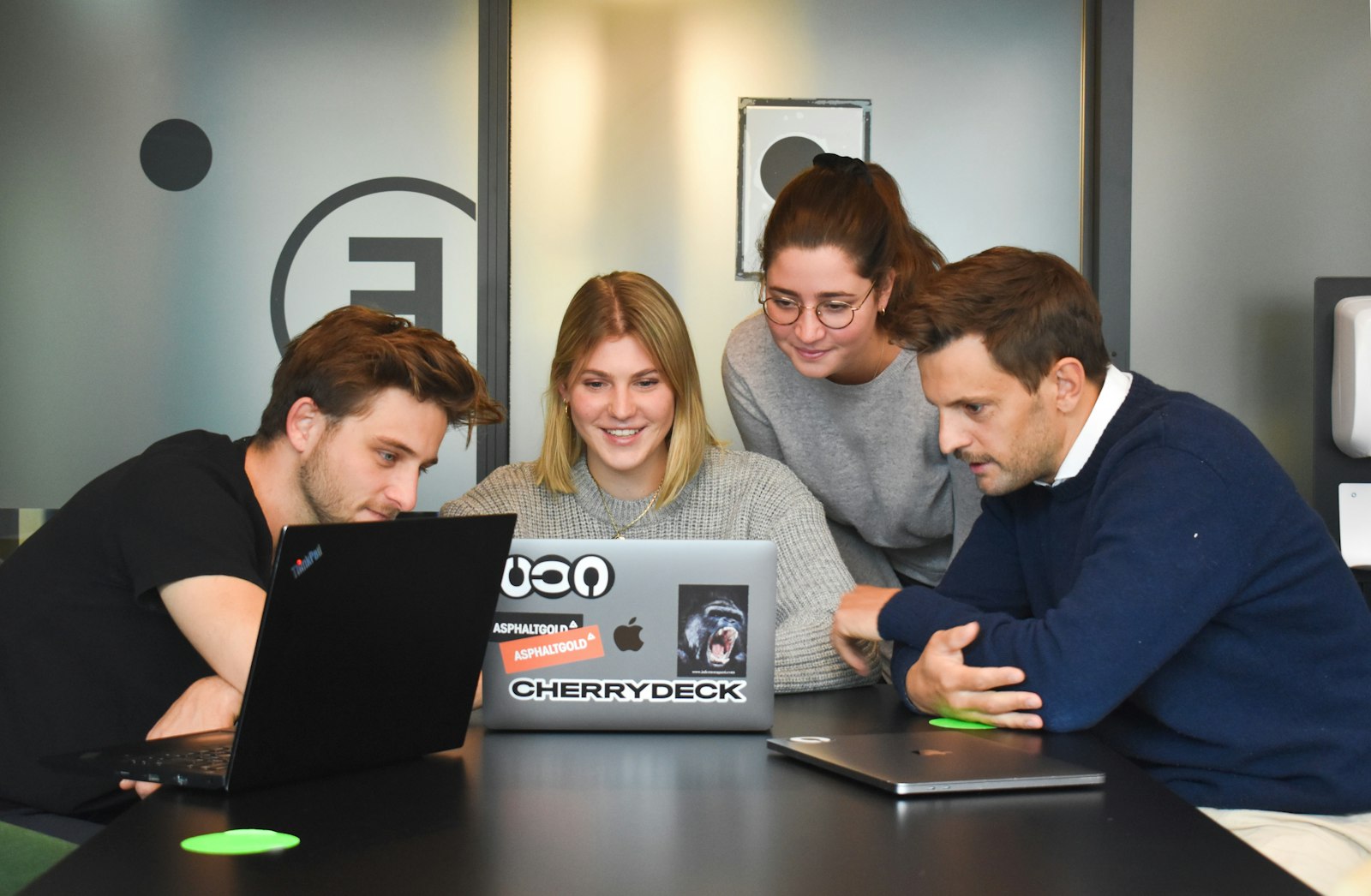Agency team collaborating around a laptop