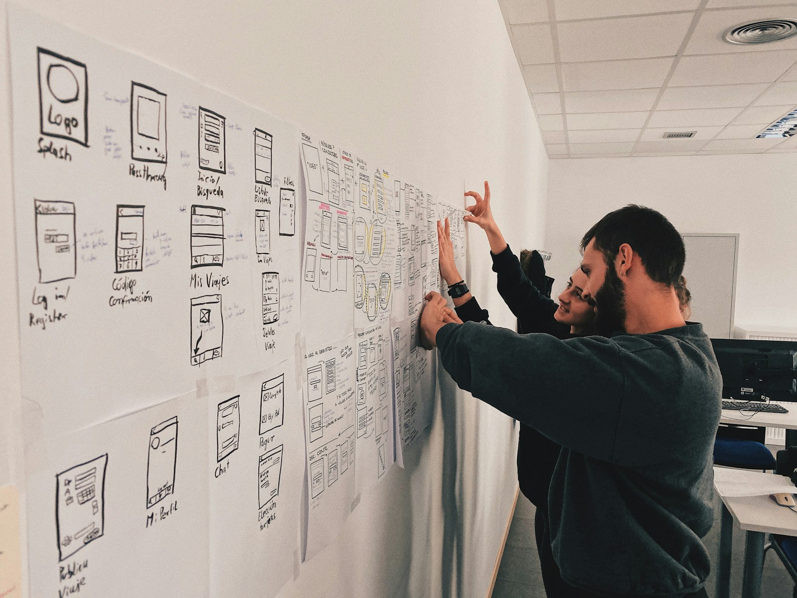 Designer standing beside a wall of sketches