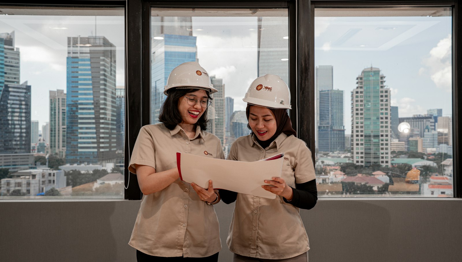 Engineers in hard hats reviewing blueprints