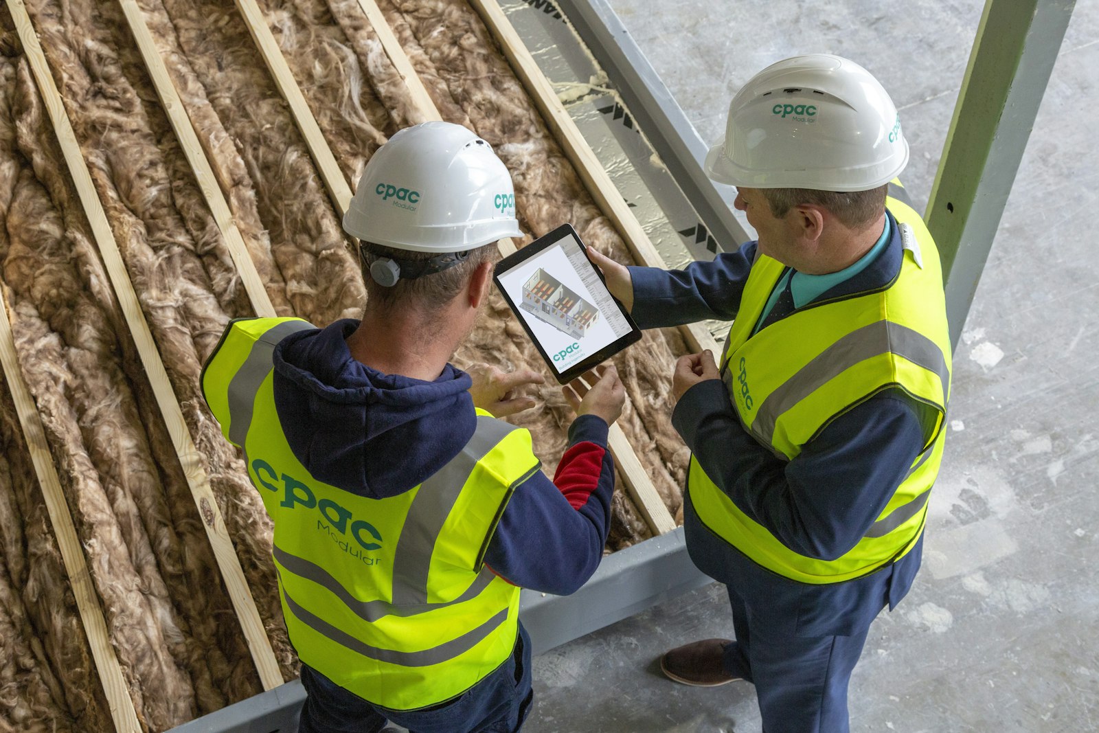 Construction workers reviewing plans on a tablet
