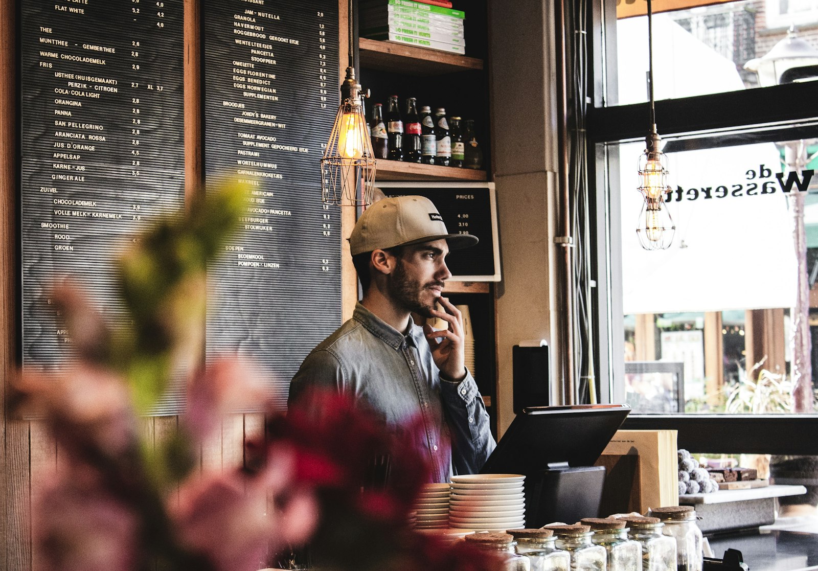 Cafe owner in front of a menu board